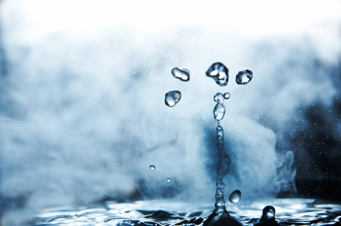 Boiling,Water,Splash,With,Steam,On,Black,Background,Closeup Boiling water splash with steam on black background closeup