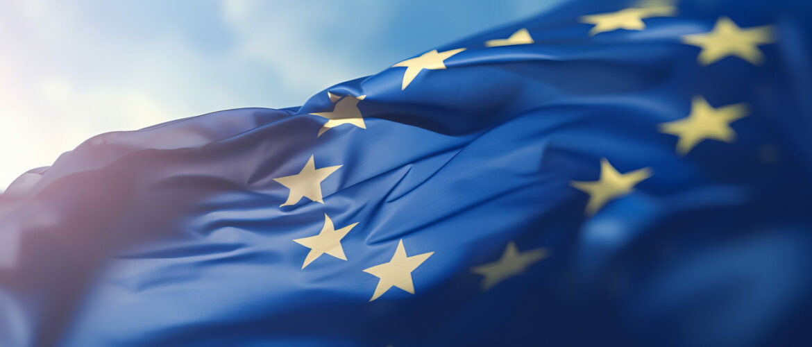 Flag of European Union waving in the breeze against a sunset sky.